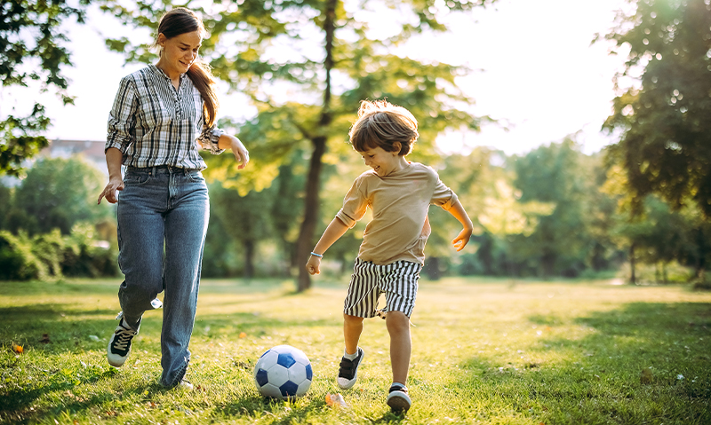 Mother and son kicking a ball